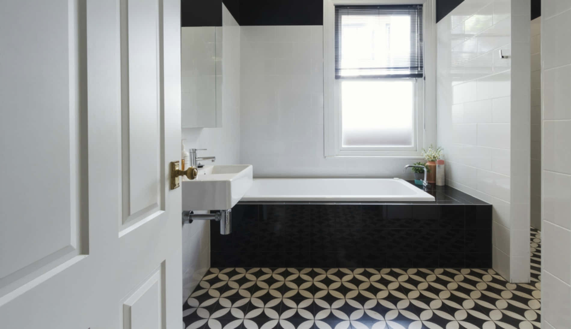 A Bathroom With Black And White Tiled Floors
