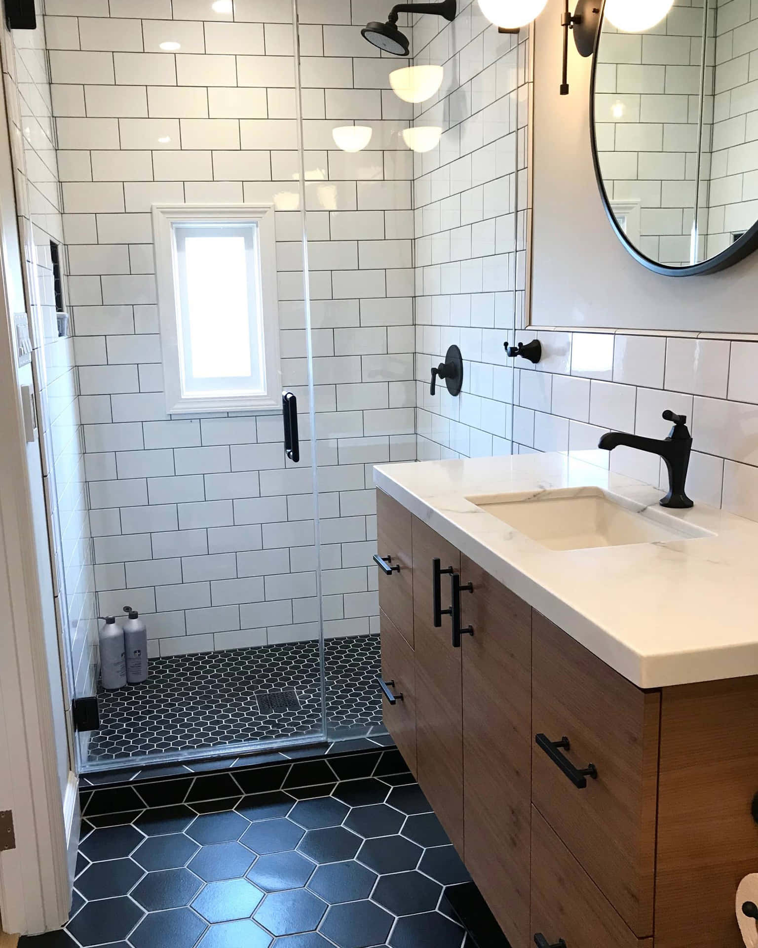 A Bathroom With Black Tile And A Shower