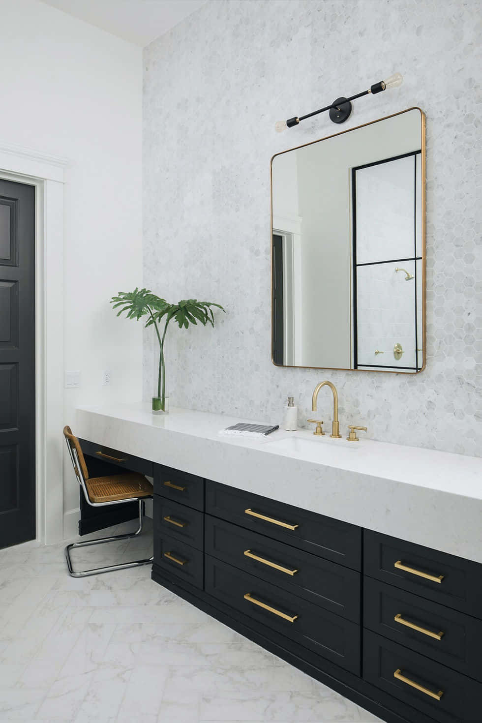A Bathroom With Black And Gold Cabinets And A Mirror
