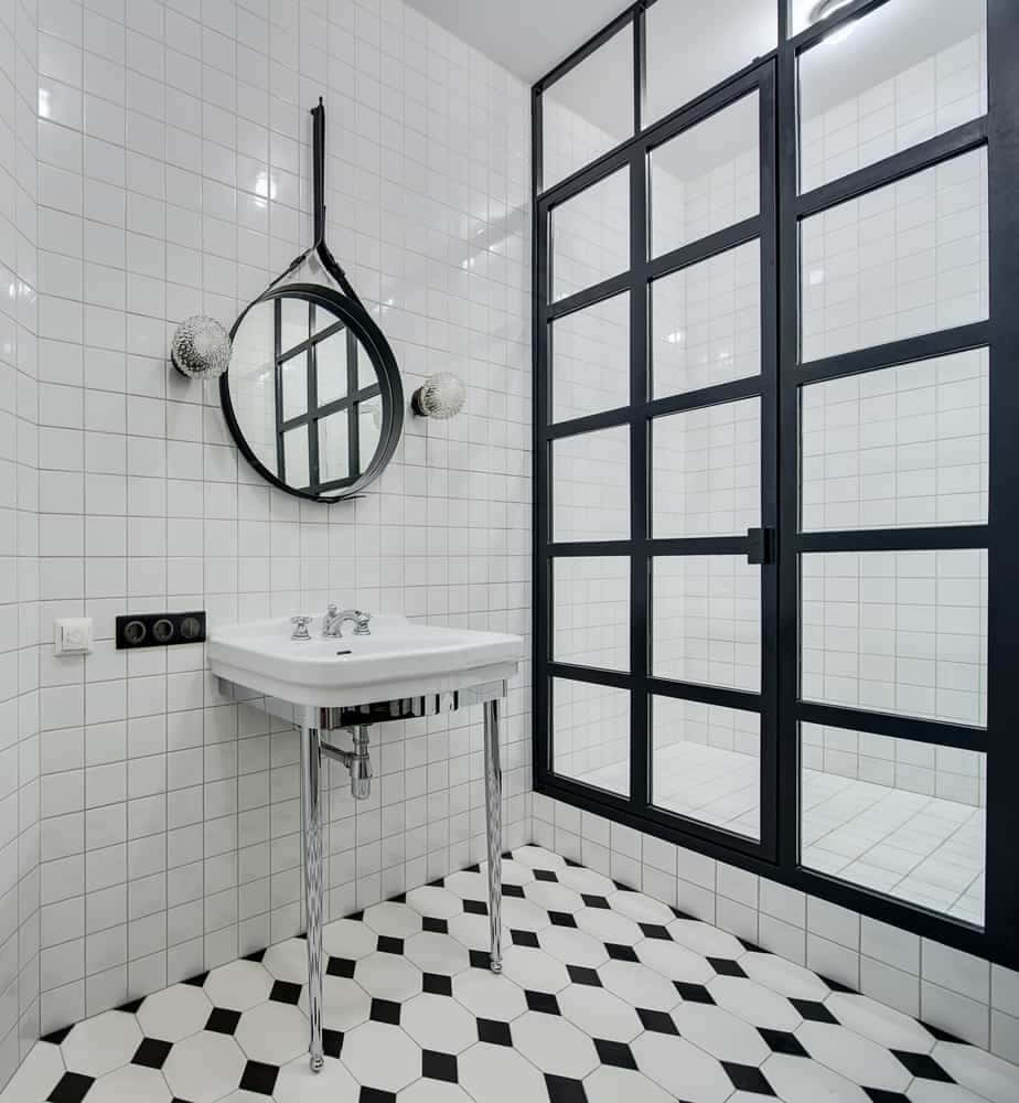 A Bathroom With Black And White Tiled Floors And A Mirror