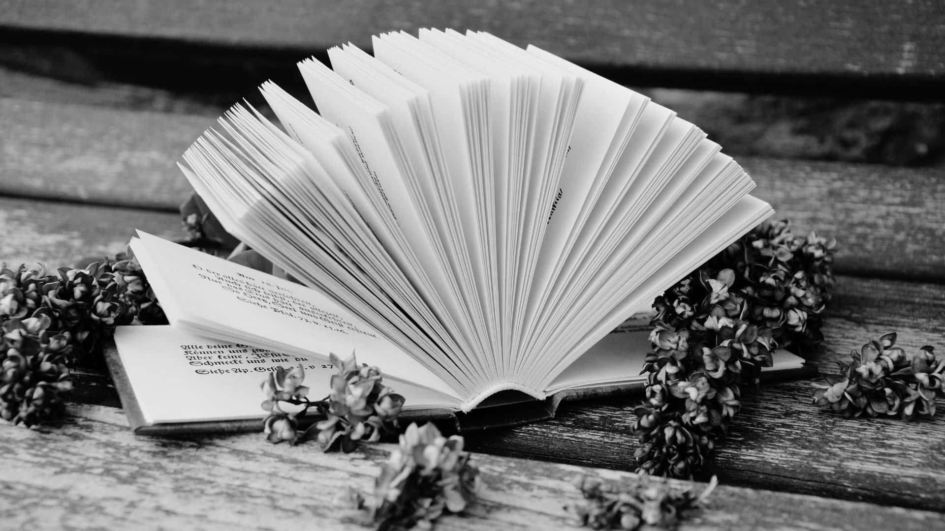 Open black and white book on table Wallpaper