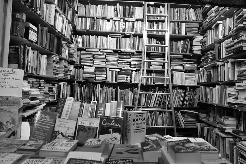 A black and white photograph of an open book on a table Wallpaper