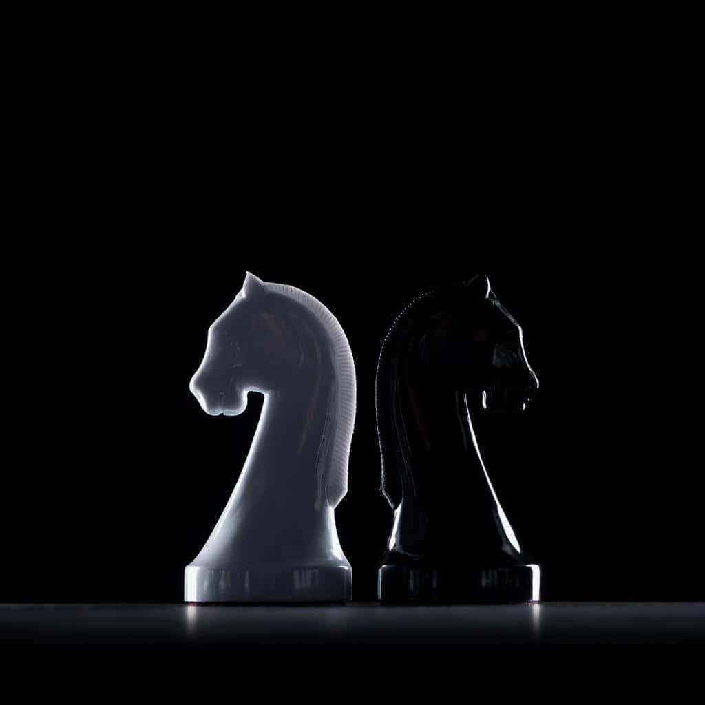 Classic black and white chess game showdown on a timeless chessboard Wallpaper