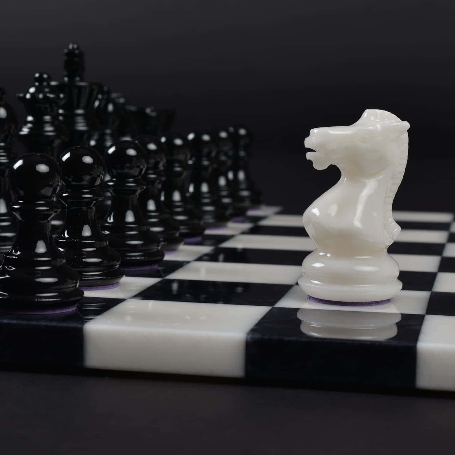 A strategic game of black and white chess pieces on a beautiful chessboard Wallpaper