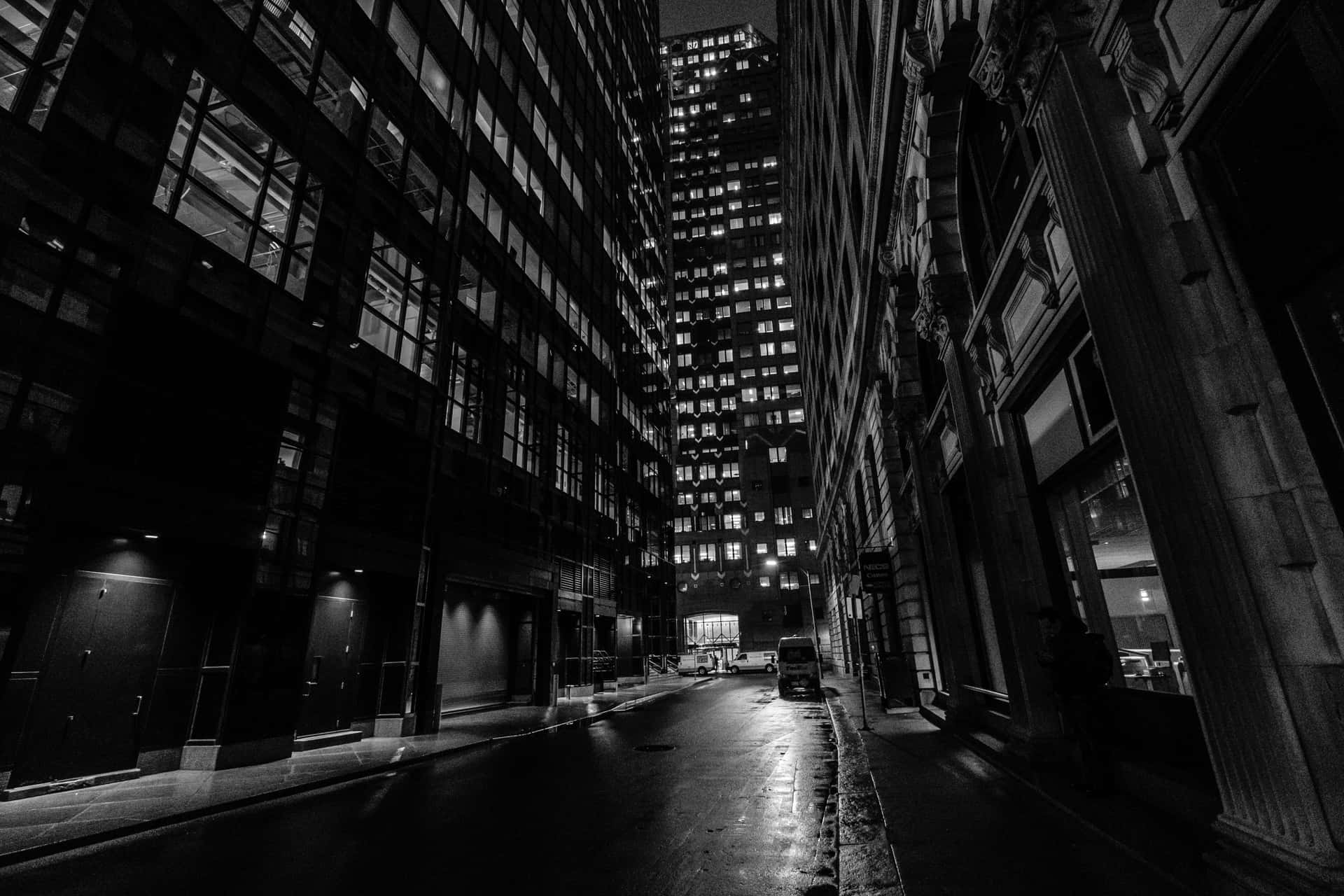 A Black And White Photo Of A City Street At Night Wallpaper