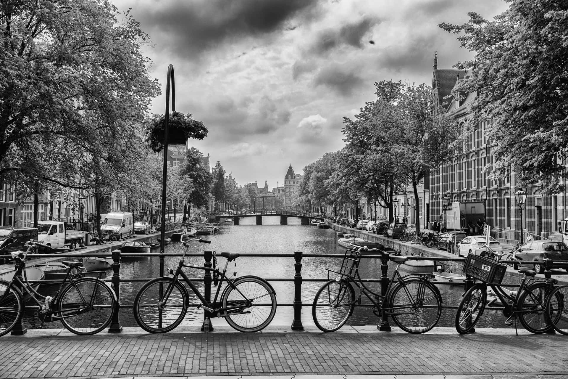 A Black And White Photo Of Bicycles Parked On A Railing Wallpaper