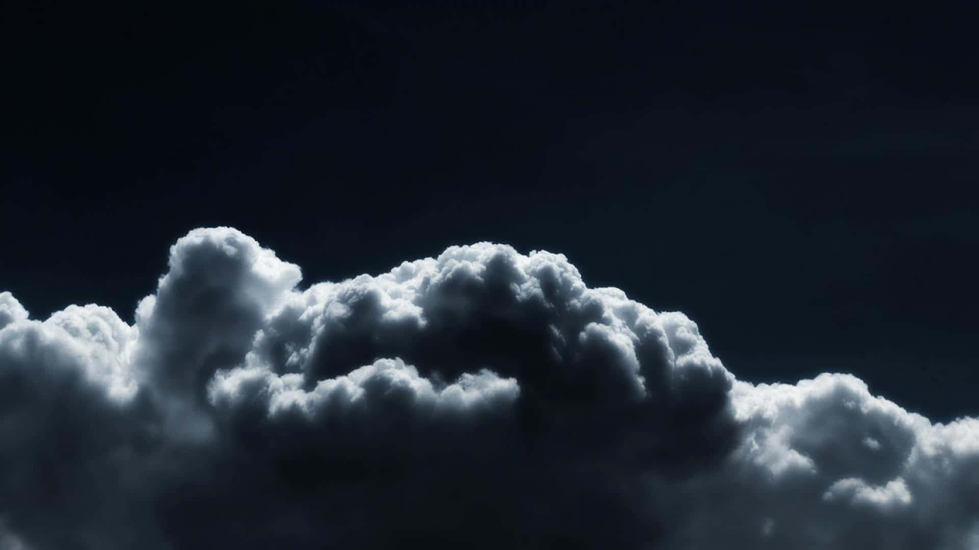 A dramatic view of low-hanging clouds against a black and white sky. Wallpaper