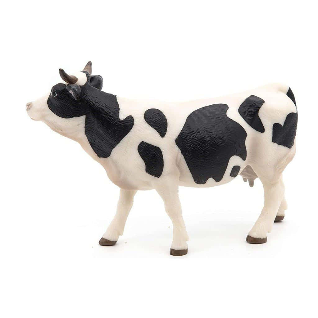 A Toy Cow Standing On A White Background