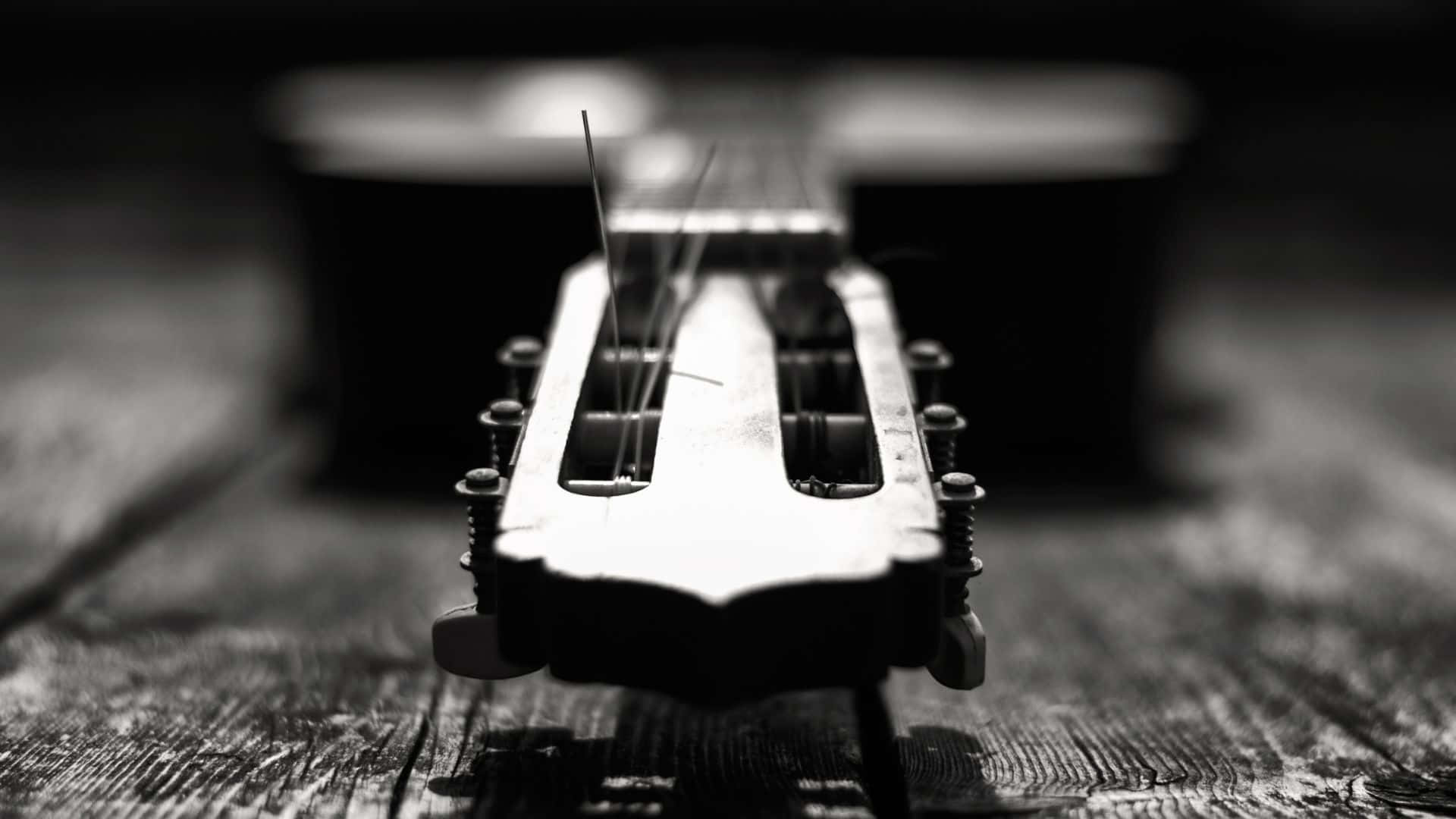 Black and white guitar resting on wall Wallpaper