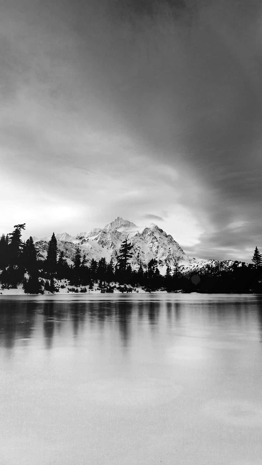 A Black And White Photo Of A Lake With Snow On It