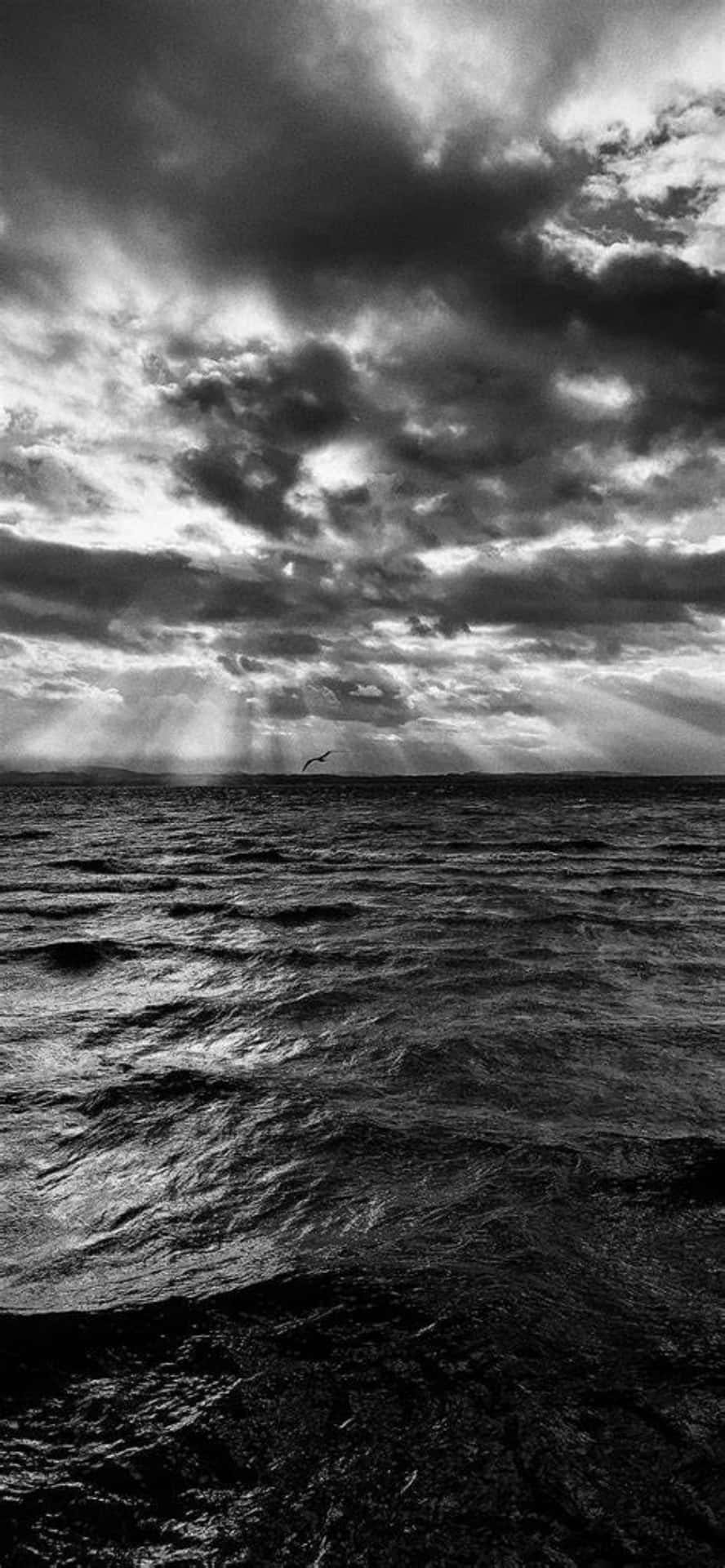 Black And White Photo Of A Cloudy Sky Over The Ocean