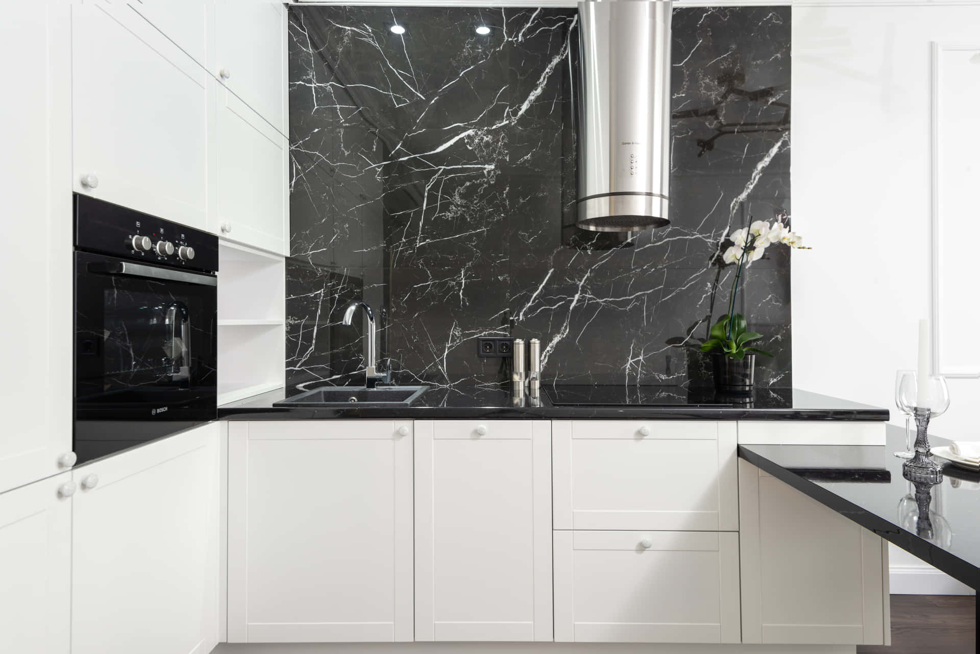A Black And White Kitchen With Marble Counter Tops