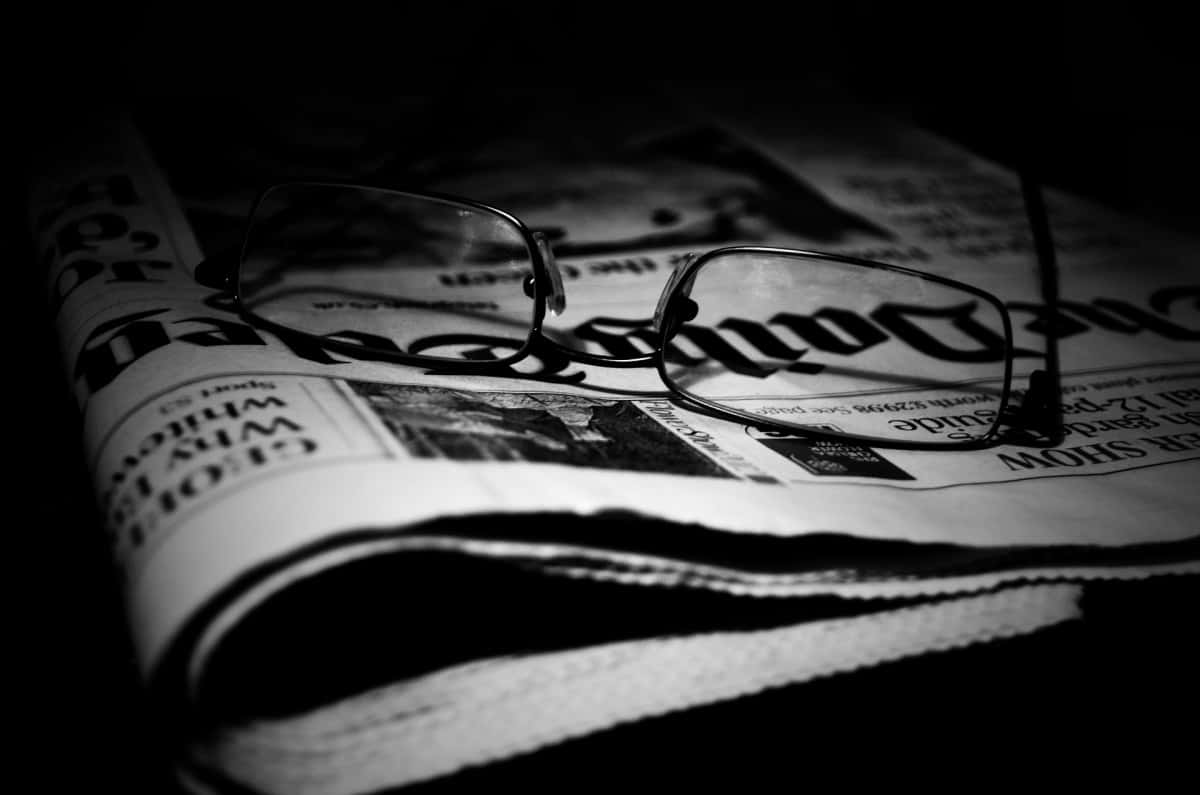 Vintage black and white newspaper on a wooden table Wallpaper