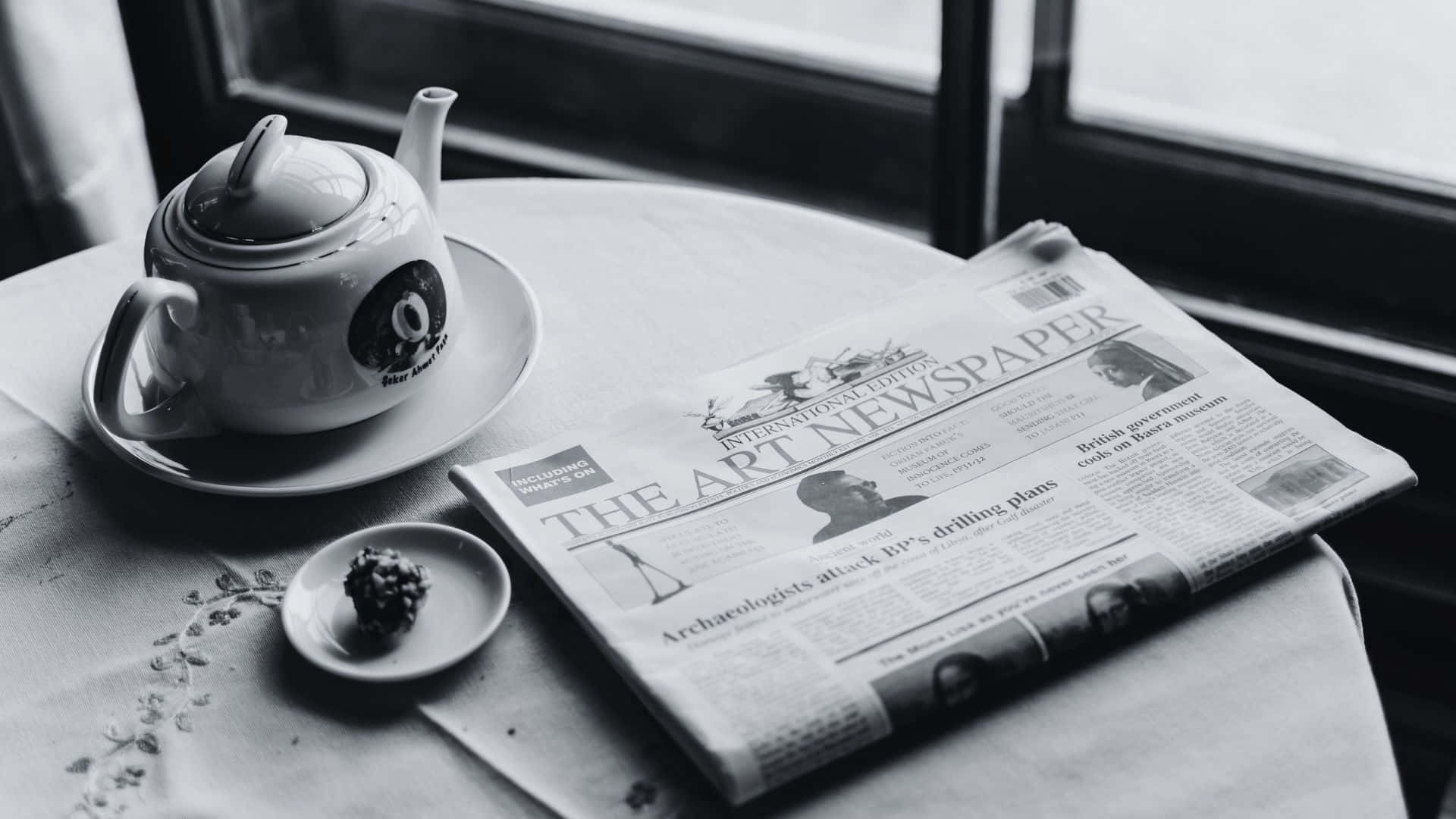 Vintage Black and White Newspaper on a Wooden Table Wallpaper