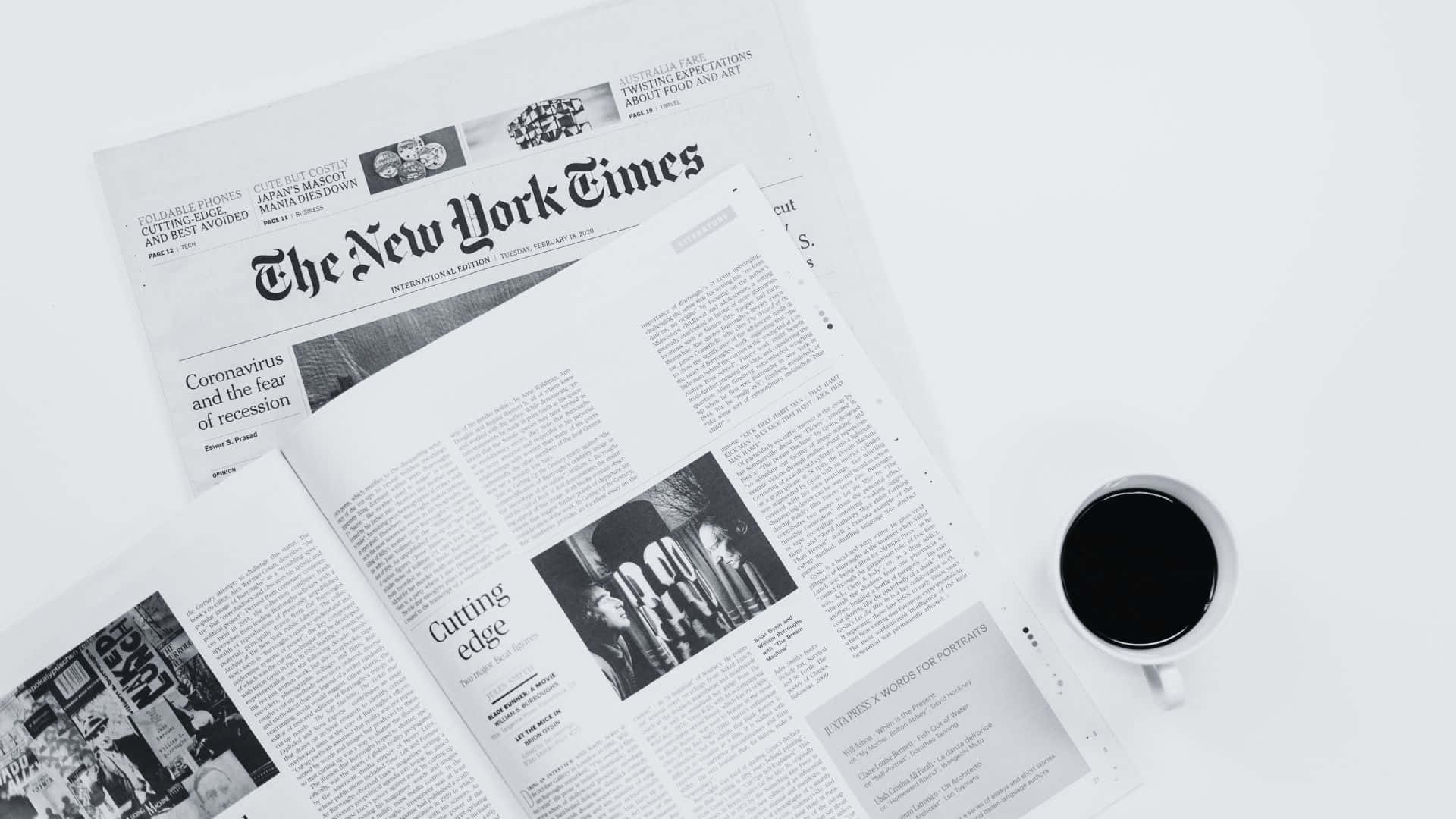 Vintage black and white newspaper on wooden table Wallpaper