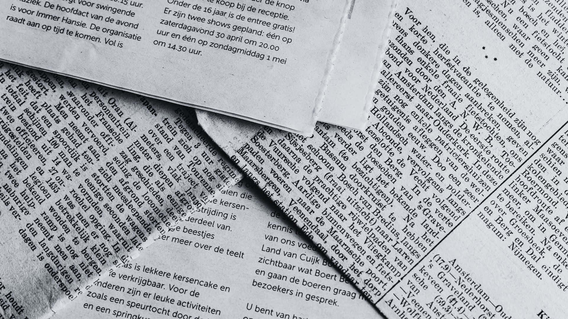 Vintage black and white newspaper on a wooden table Wallpaper