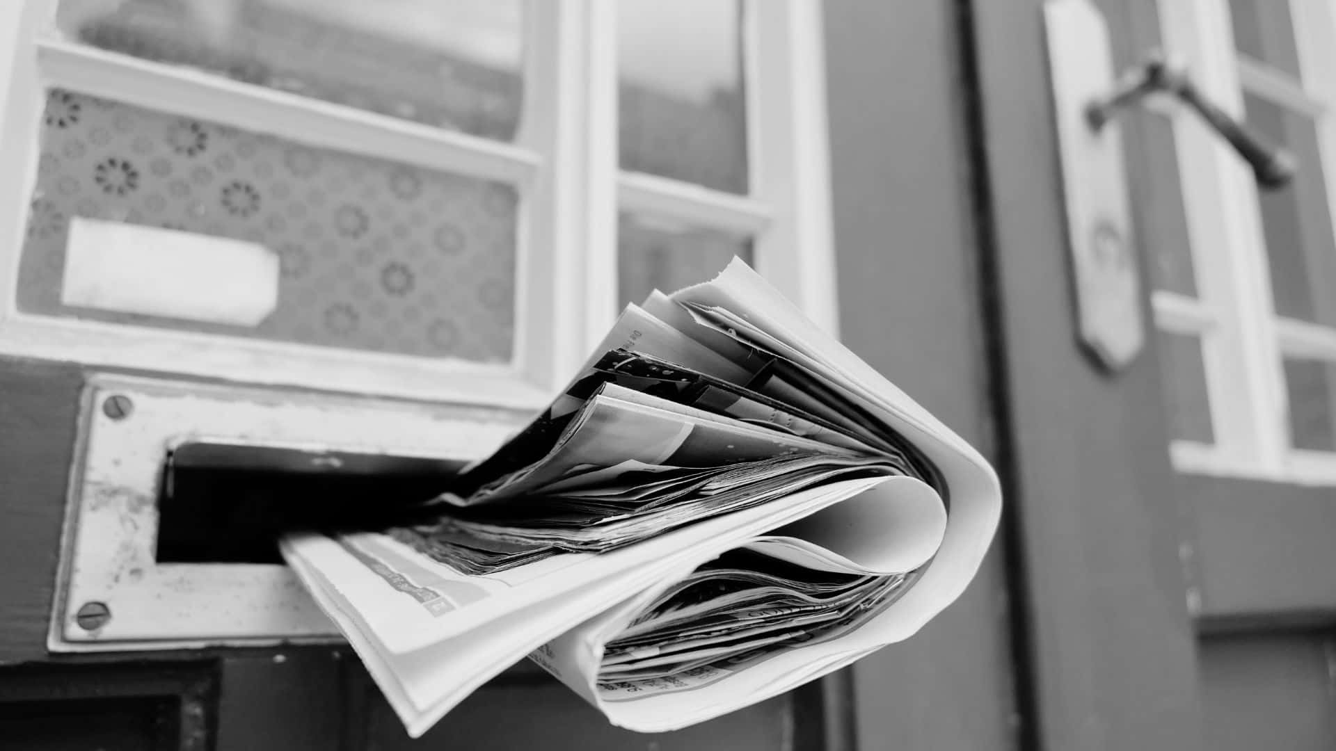 Vintage black and white newspaper on wooden surface Wallpaper