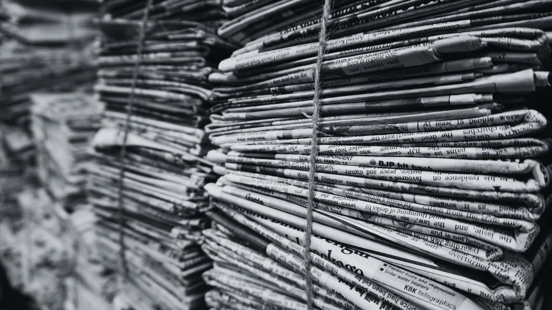 Vintage black and white newspaper on a wooden table Wallpaper