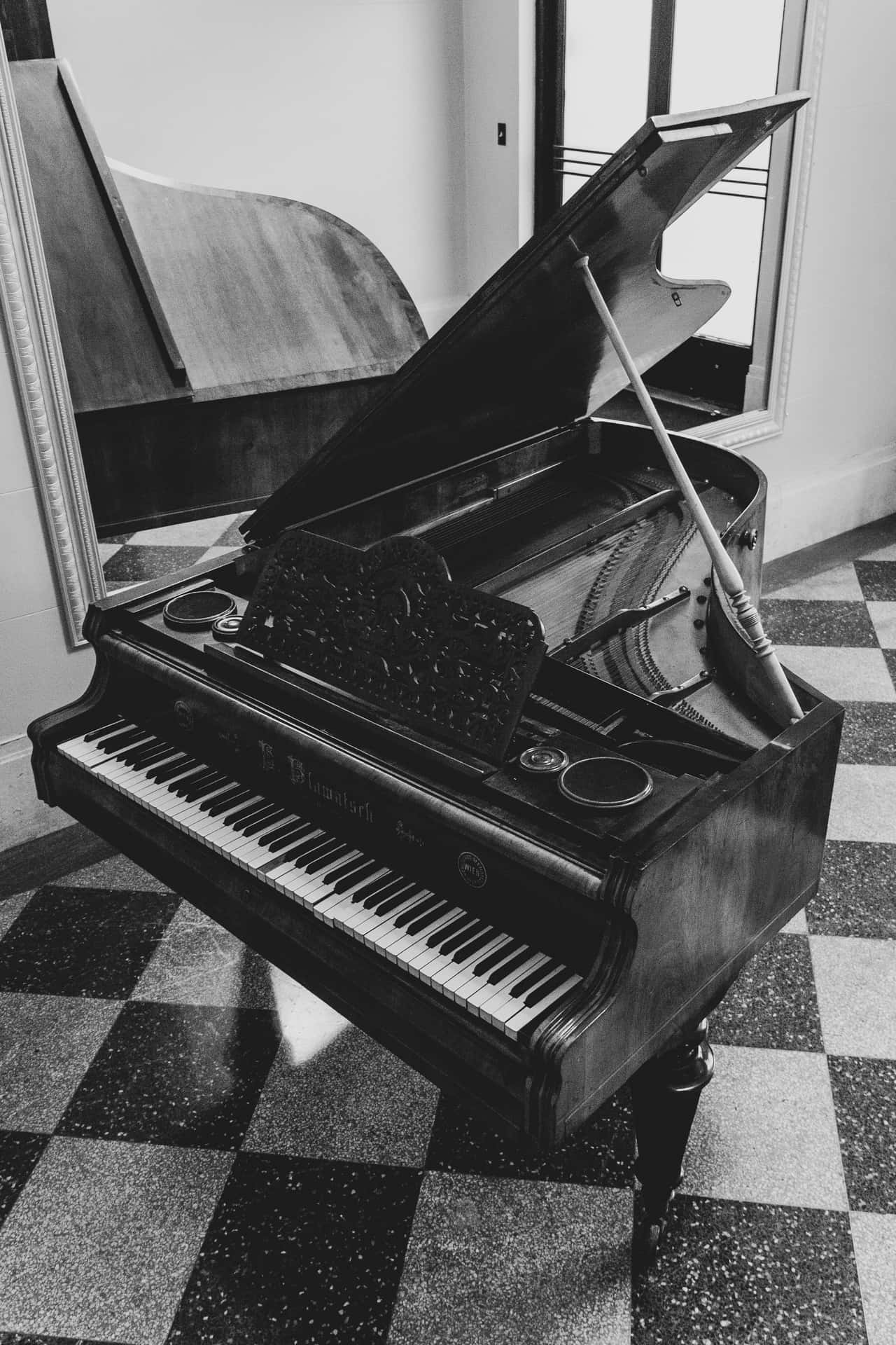 A black and white grand piano in an elegant, minimalist setting. Wallpaper