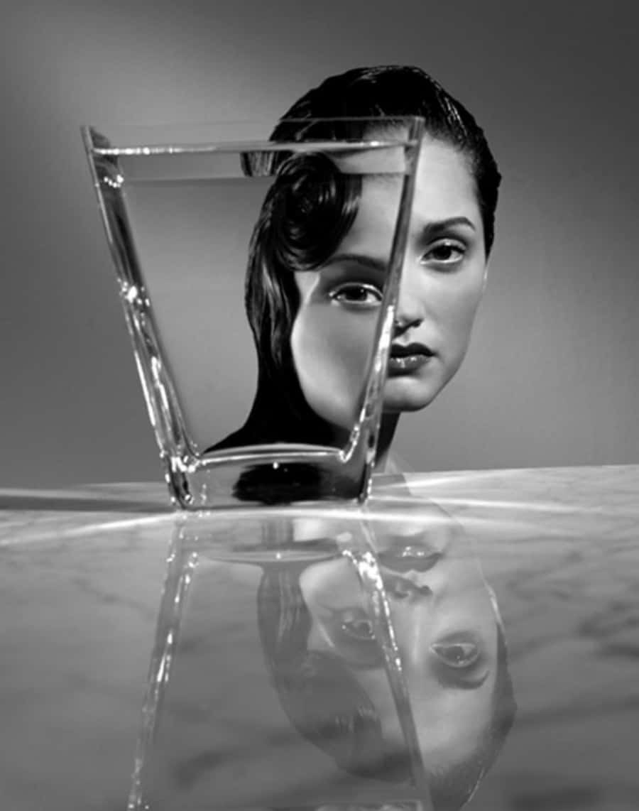 a woman's face is shown in a glass of water