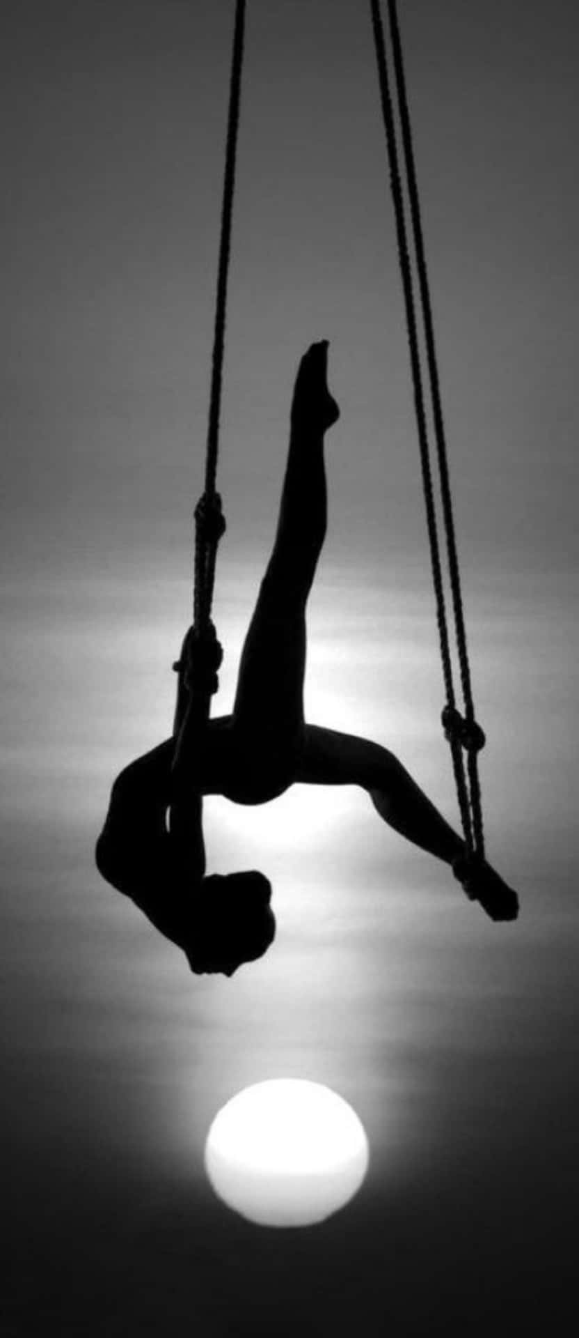 a silhouette of a person hanging from a rope