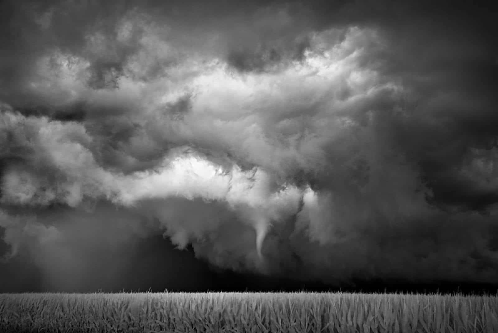 Dramatic black and white storm over an open field Wallpaper