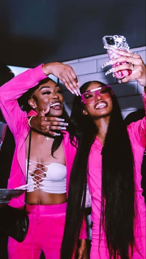 Two Women In Pink Outfits Taking A Selfie Wallpaper