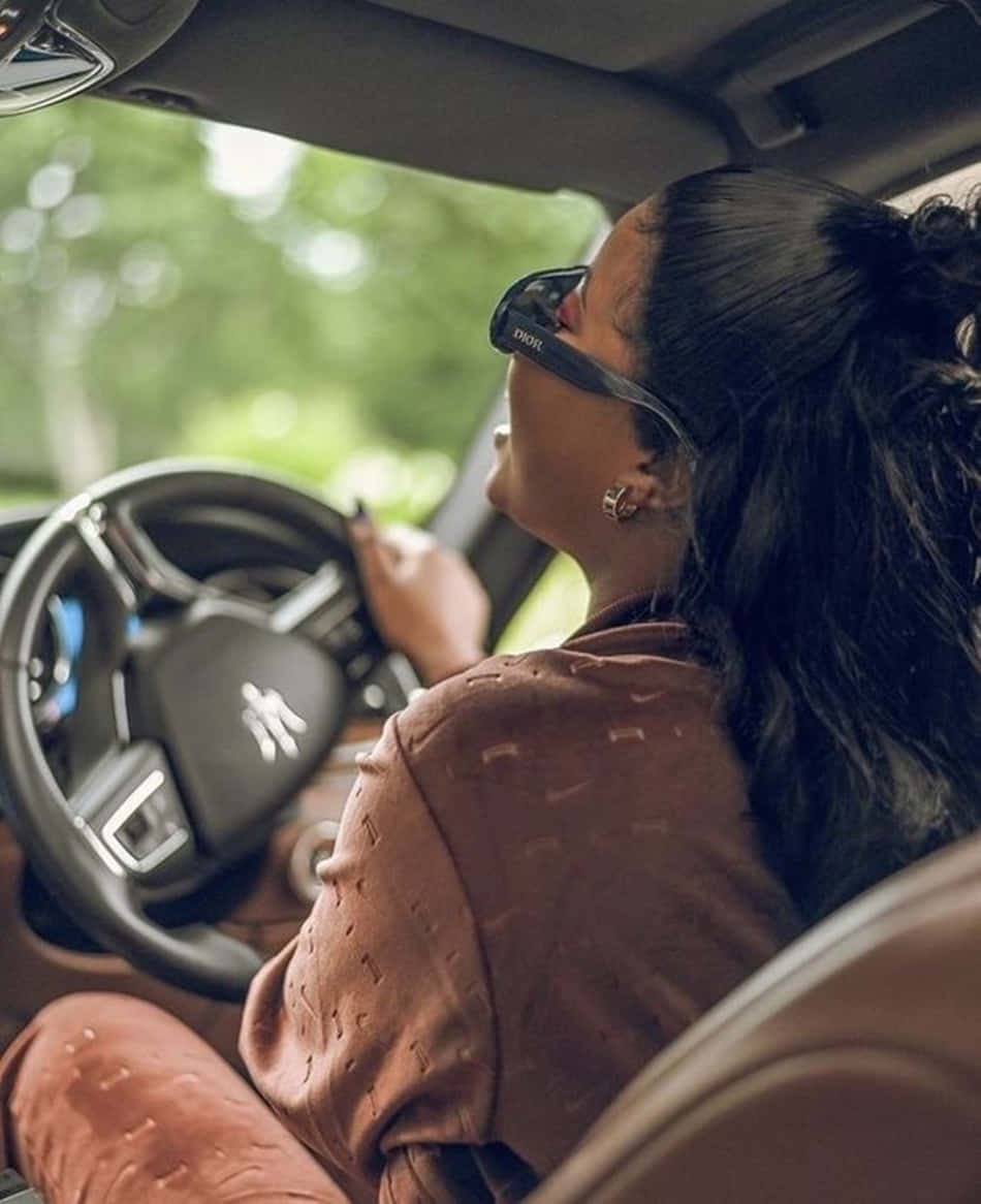 Einefrau Fährt Ein Auto Mit Sonnenbrille. Wallpaper