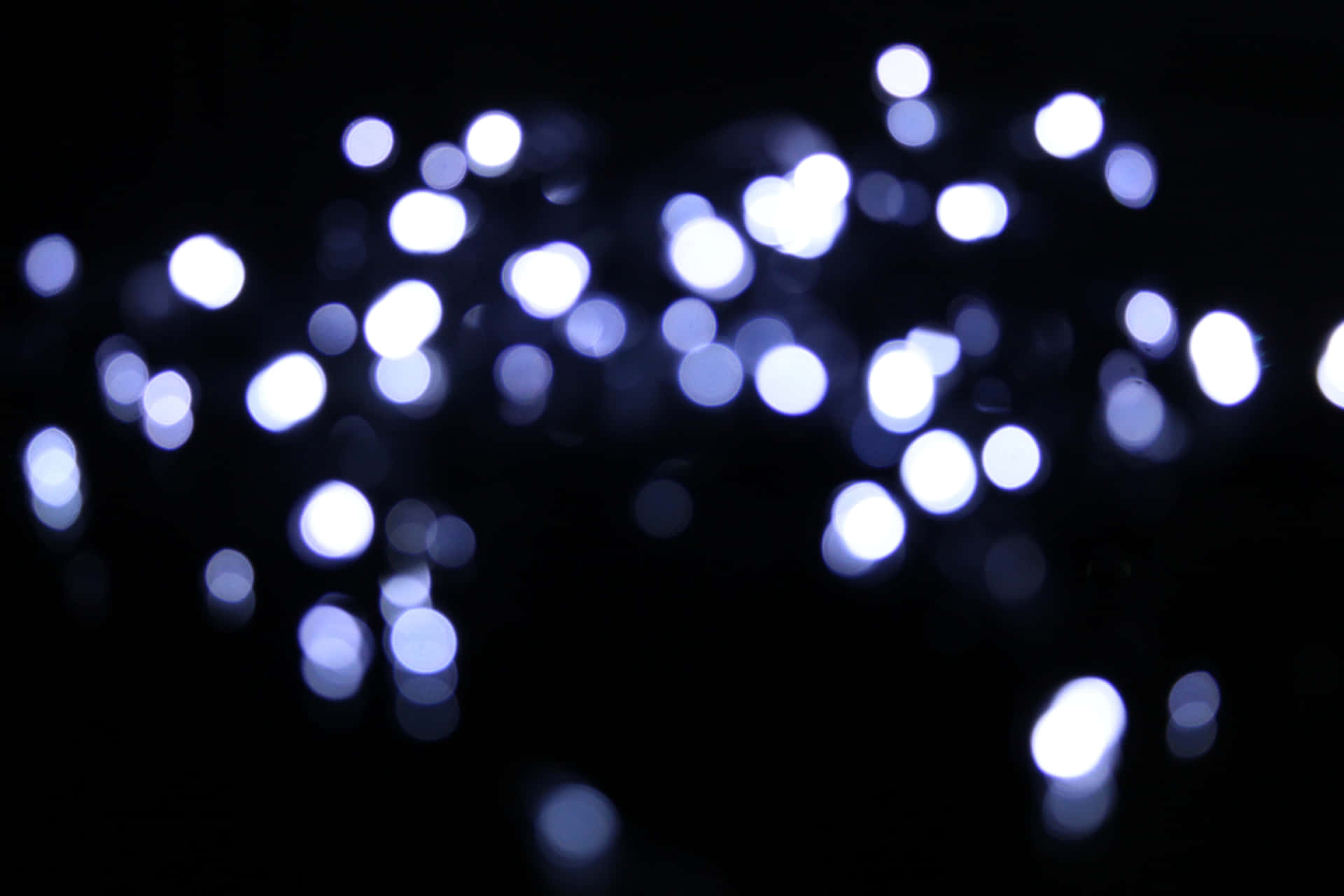 A Close Up Of White Lights On A Dark Background Wallpaper