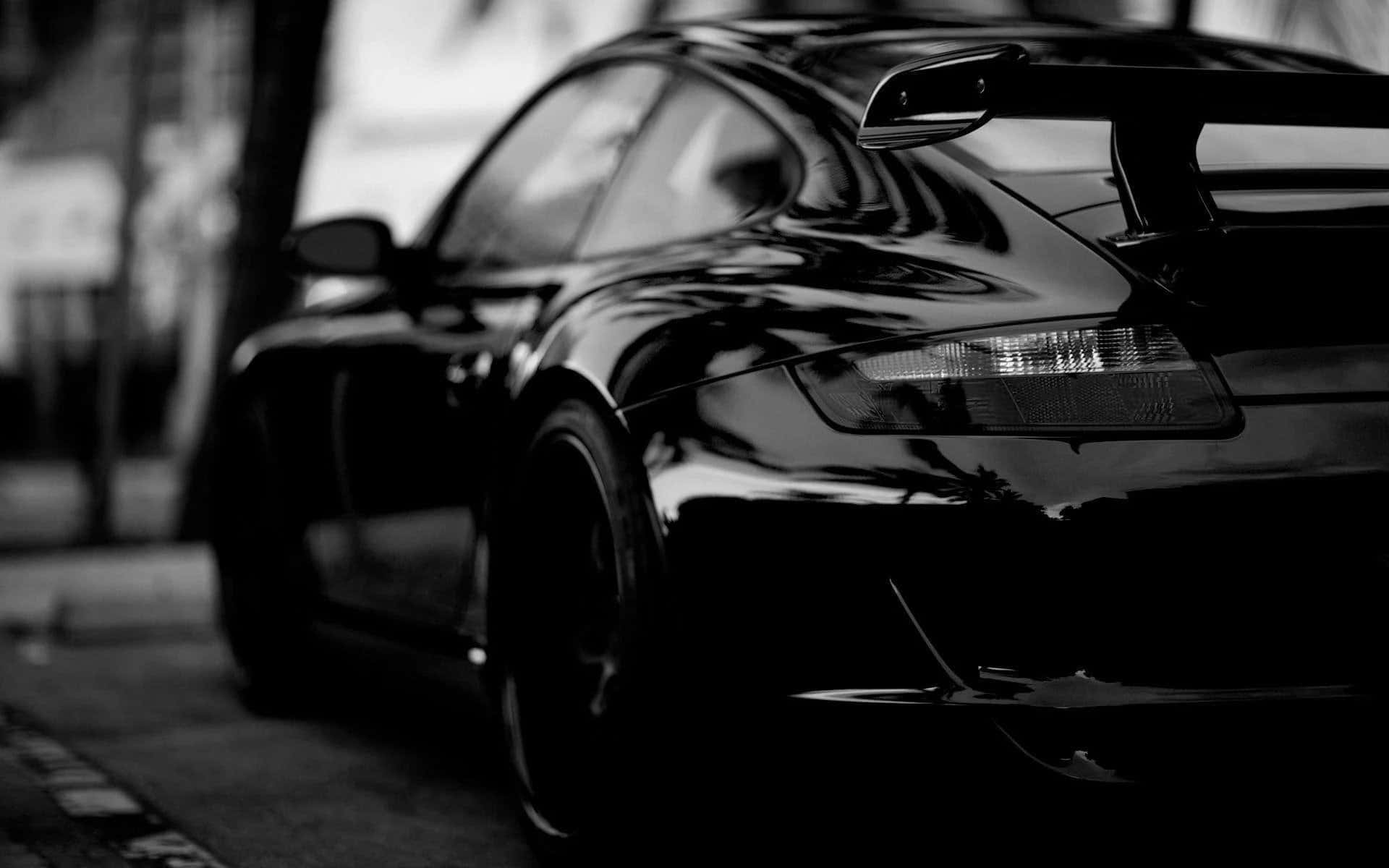 A sleek and shiny black car on the open road.