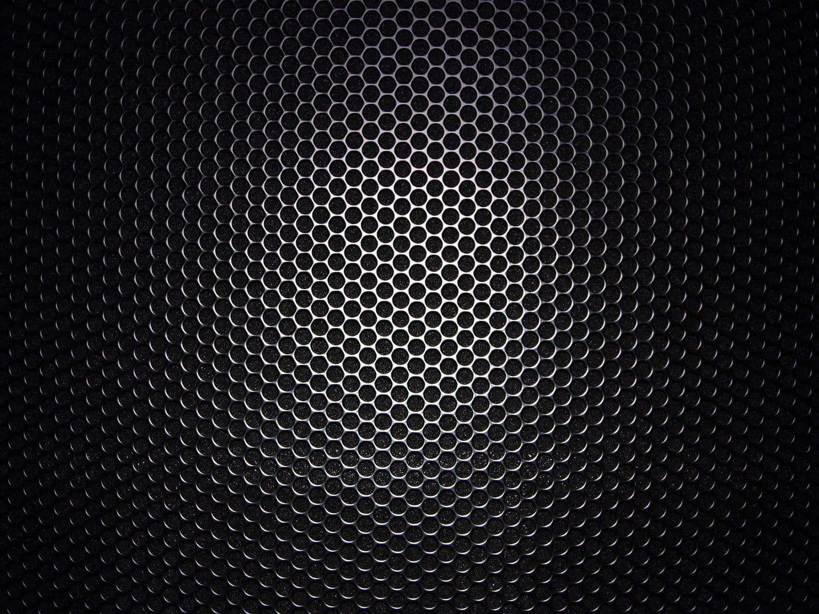 A Black Metal Grille With Holes In It Wallpaper