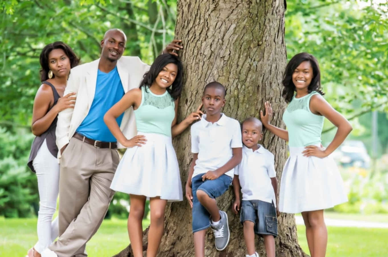 Einefamilie Posiert Für Ein Foto Vor Einem Baum.