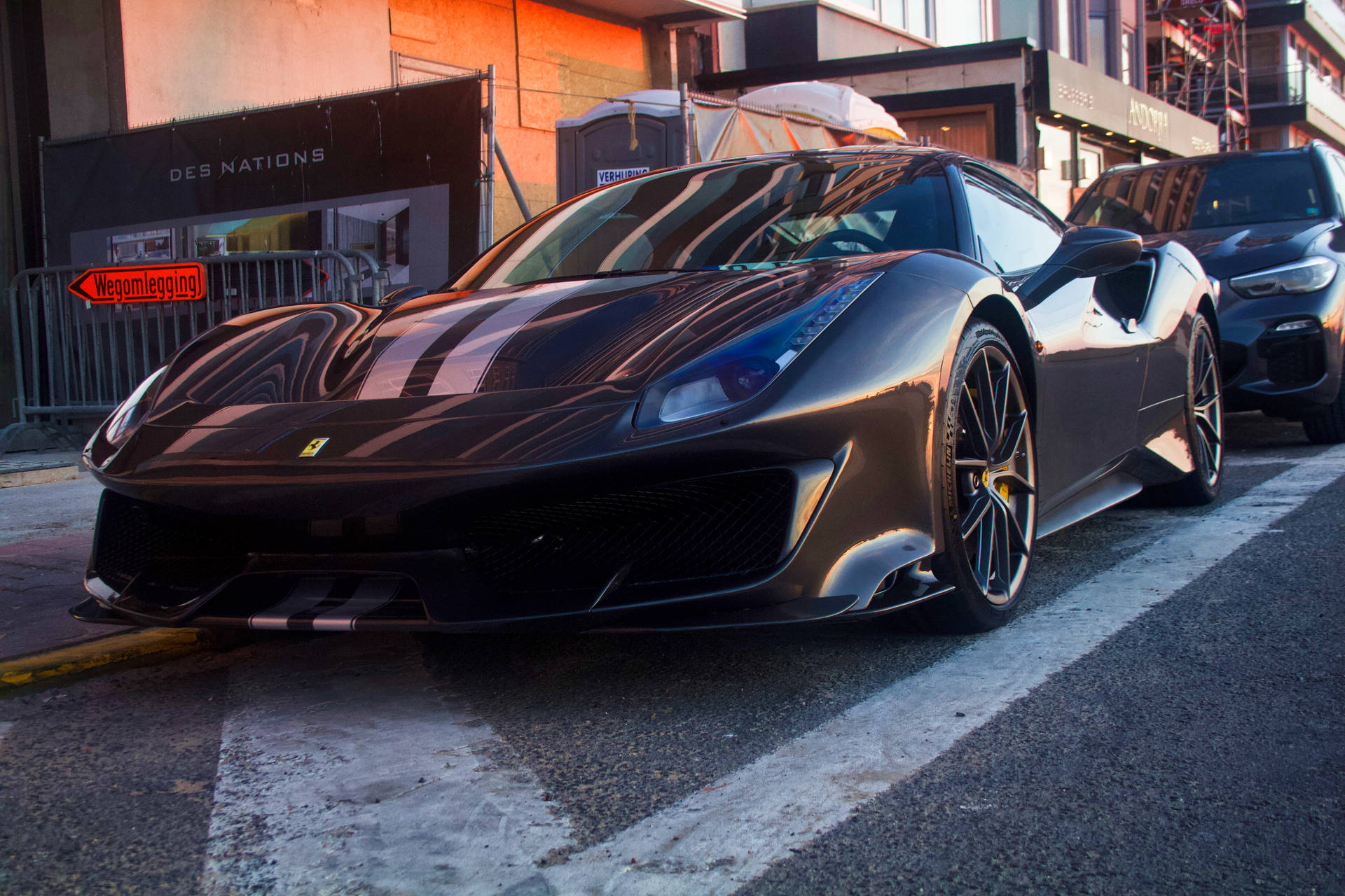 Black Ferrari sports car parked on street wallpaper.