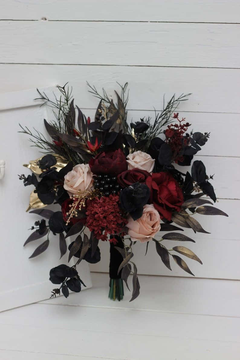 A Black And Red Bouquet Hanging On A White Wall