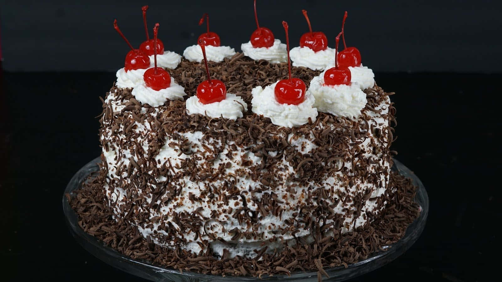 Delicious black forest cake with cherries and chocolate shavings Wallpaper