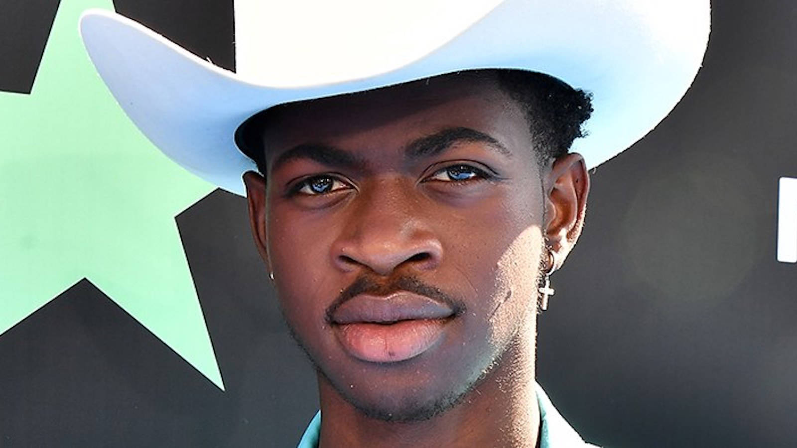 Black Gay Man Lil Nax X In A White Cowboy Hat Background