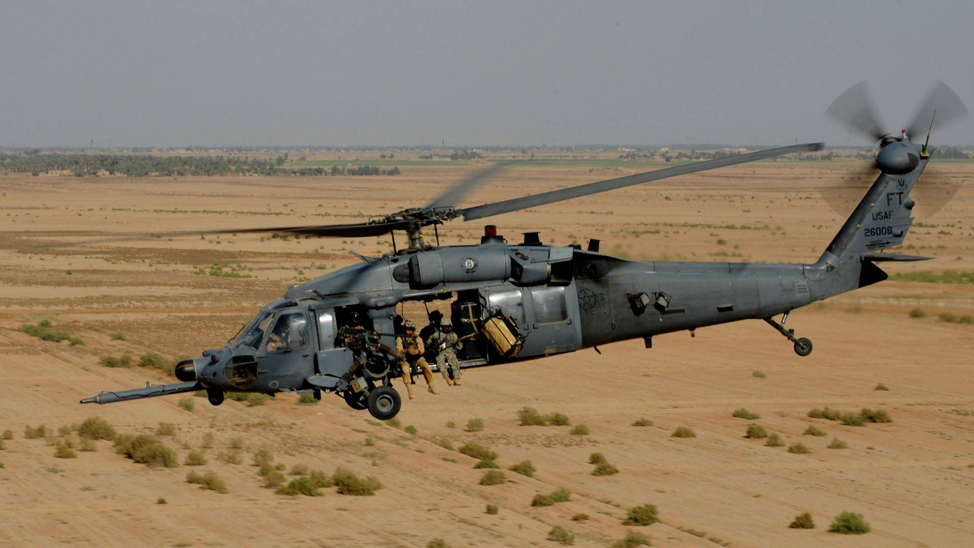 Et sort Hawk-helikopter, der svæver i himlen. Wallpaper