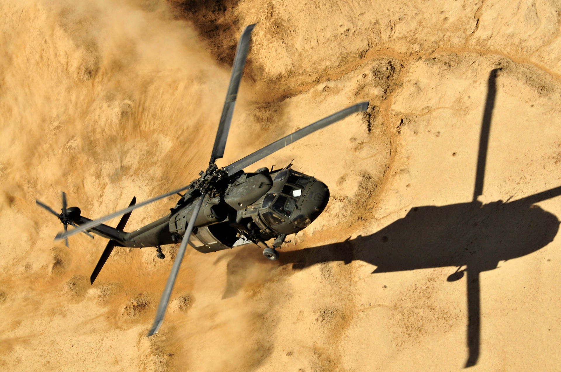 Schwarzerblack Hawk Helikopter Landet Staubend. Wallpaper