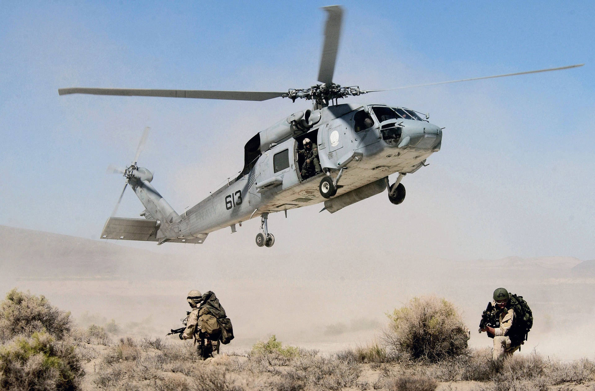 En helikopter flyver over en gruppe soldater. Wallpaper