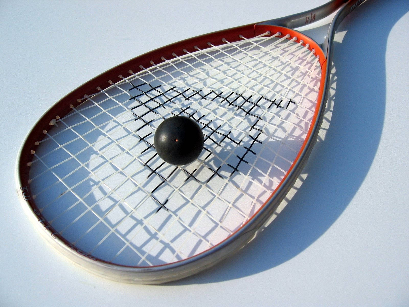 Black Hollow Ball On Squash Racket Background