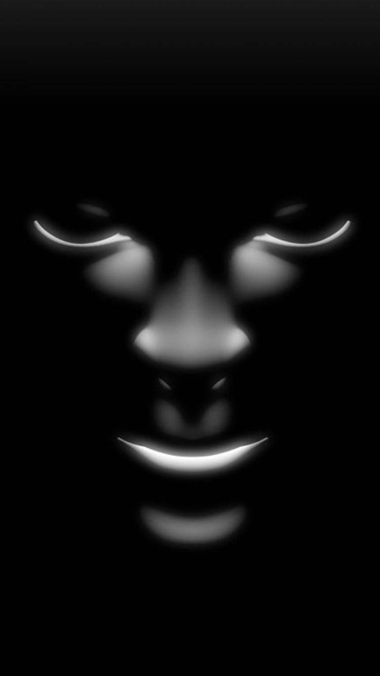 Caption: Black Horror Face Mask Illuminated in Darkness Wallpaper