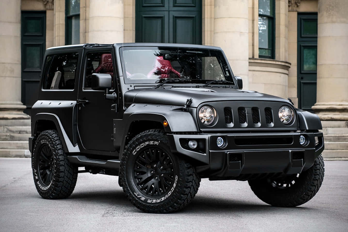 A Black Jeep Parked In Front Of A Building