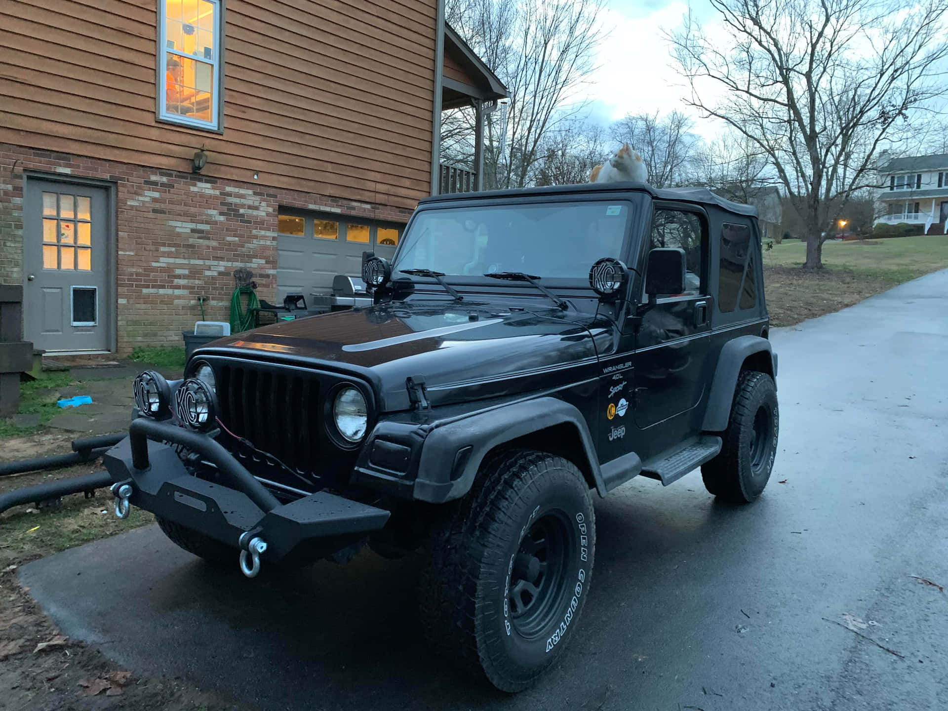 A Black Jeep Parked In Front Of A House