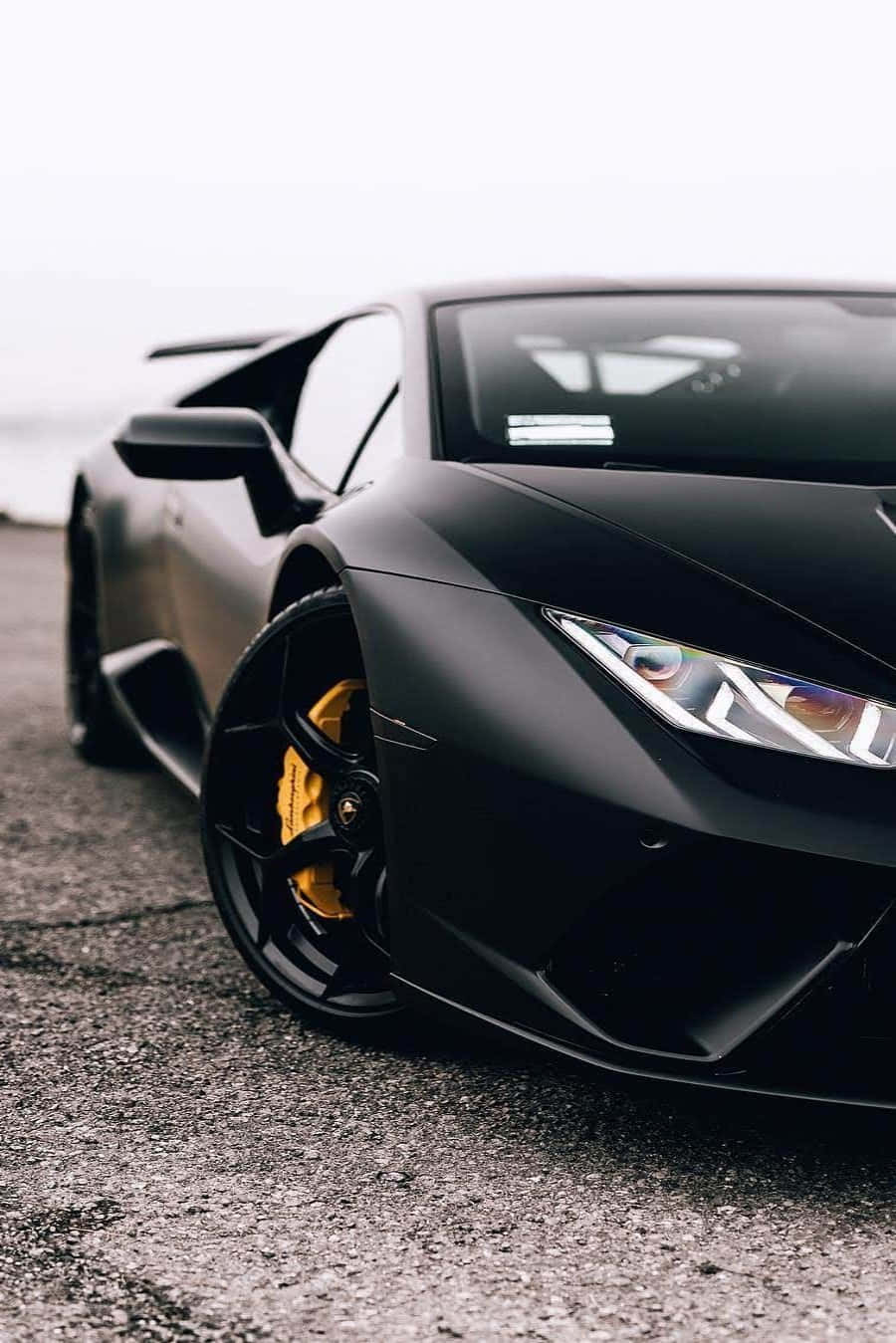 En sort Lamborghini parkeret ved siden af vejen Wallpaper