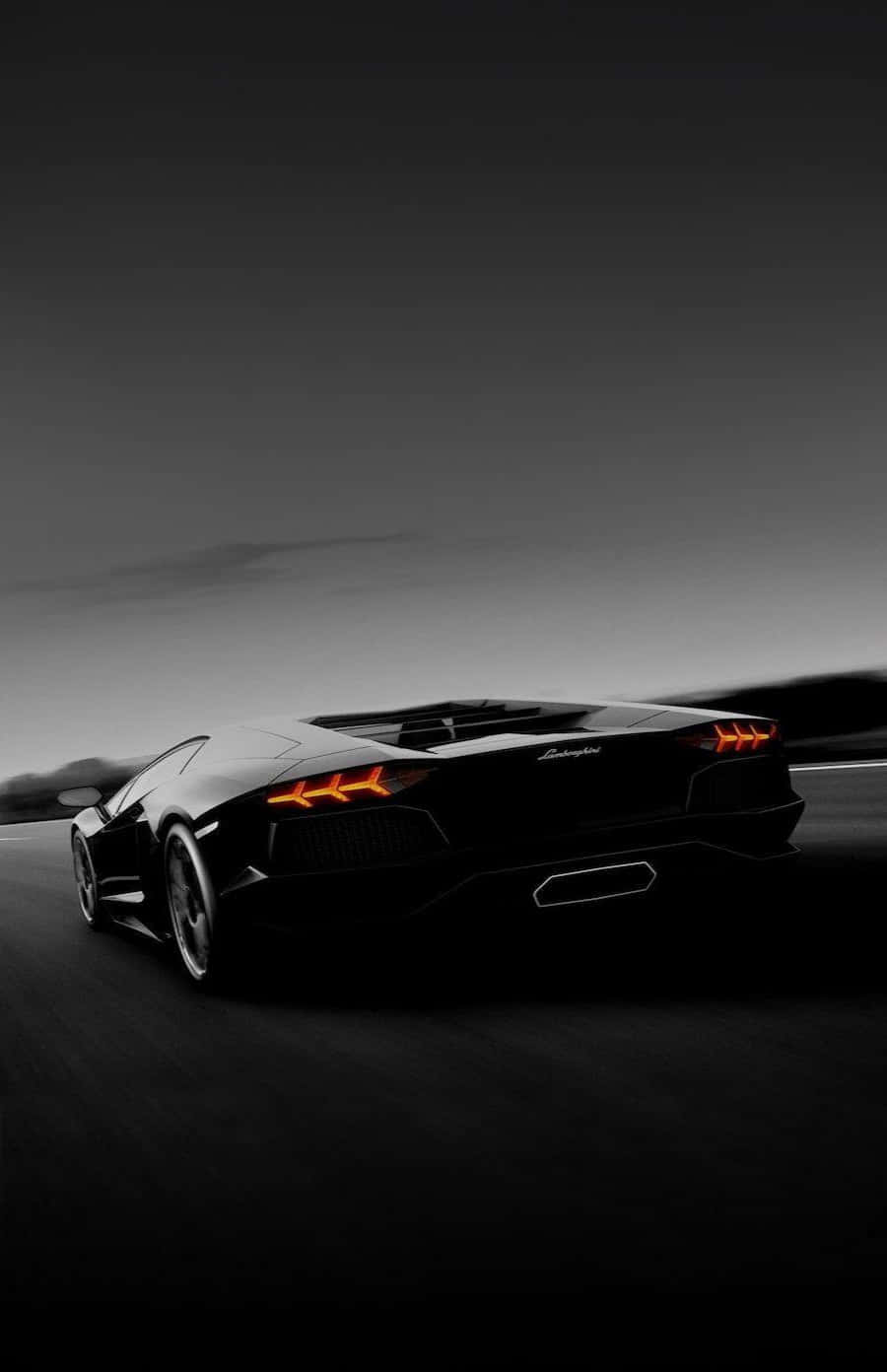 Cruise ned Autobahnen i stil i en sort Lamborghini. Wallpaper