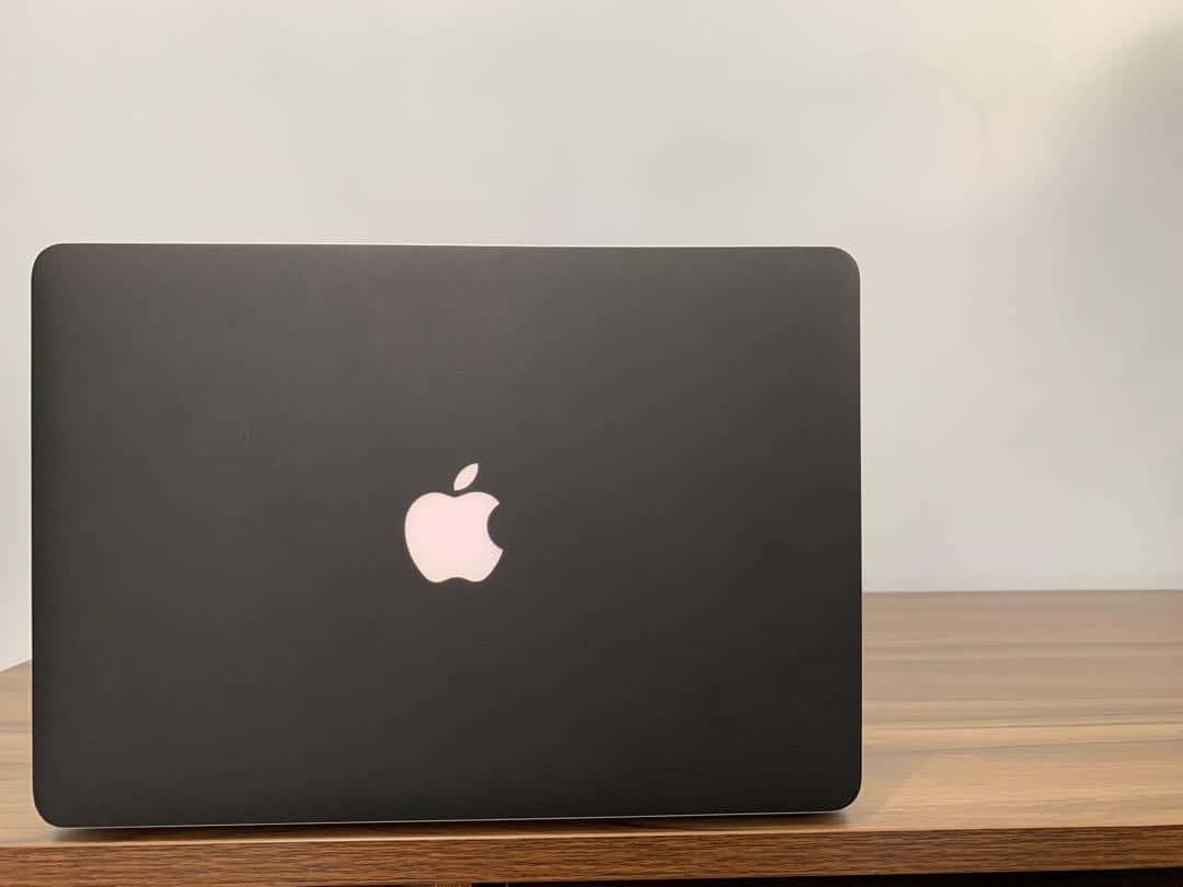 The latest Black Macbook for more efficient computing Wallpaper