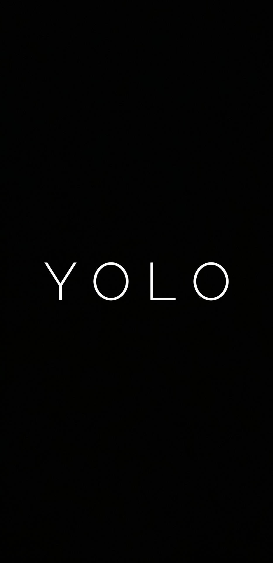 Embrace Life with 'YOLO' Motivation on a Black Backdrop Wallpaper