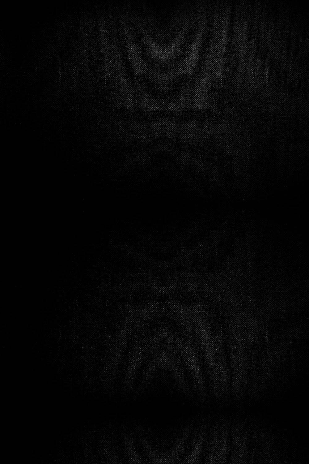 En sort baggrund med et lys på den. Wallpaper