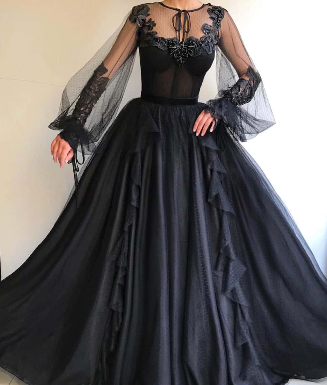 En kvinde iført en sort kjole med blonderærmer