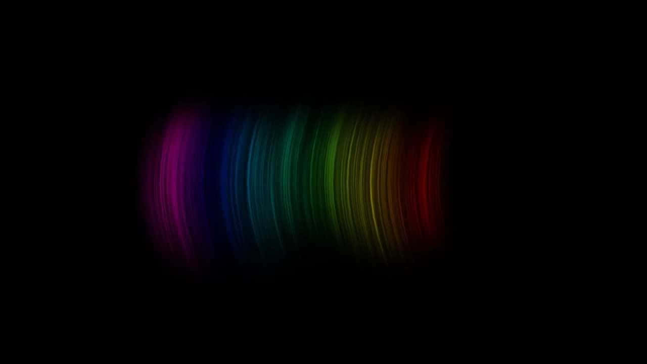Brightly colored rainbow cutting through a pitch black sky. Wallpaper